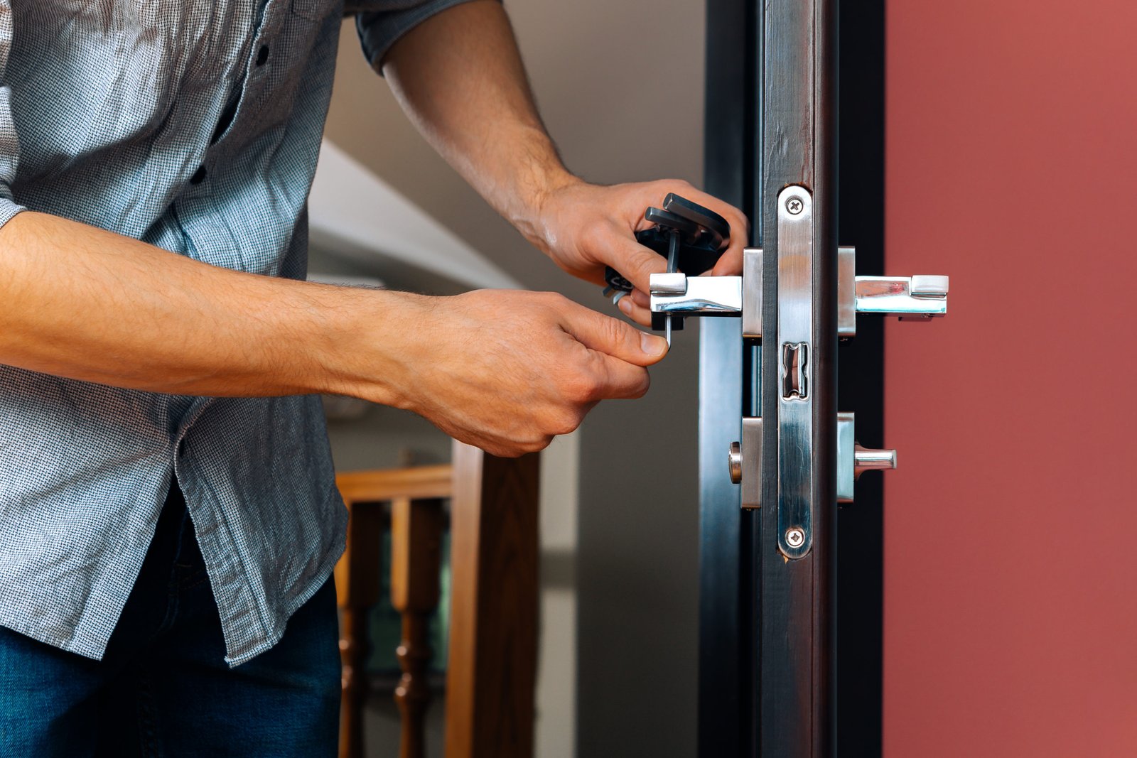man repairing the doorknob. closeup of worker's hands installing